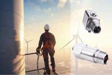A construction worker standing at the top of a wind turbine considering how an Accelerometer can monitor these and why it is essential. 