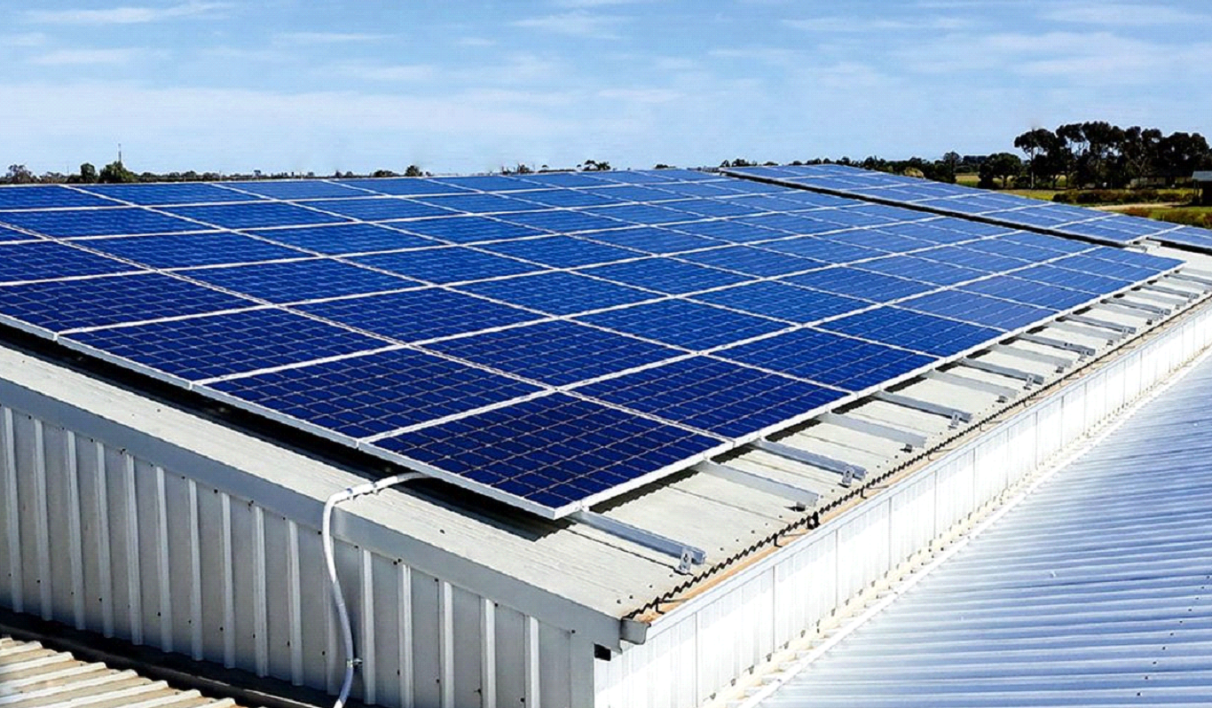 Green energy project being implemented with solar panels on the roof of a warehosue. 